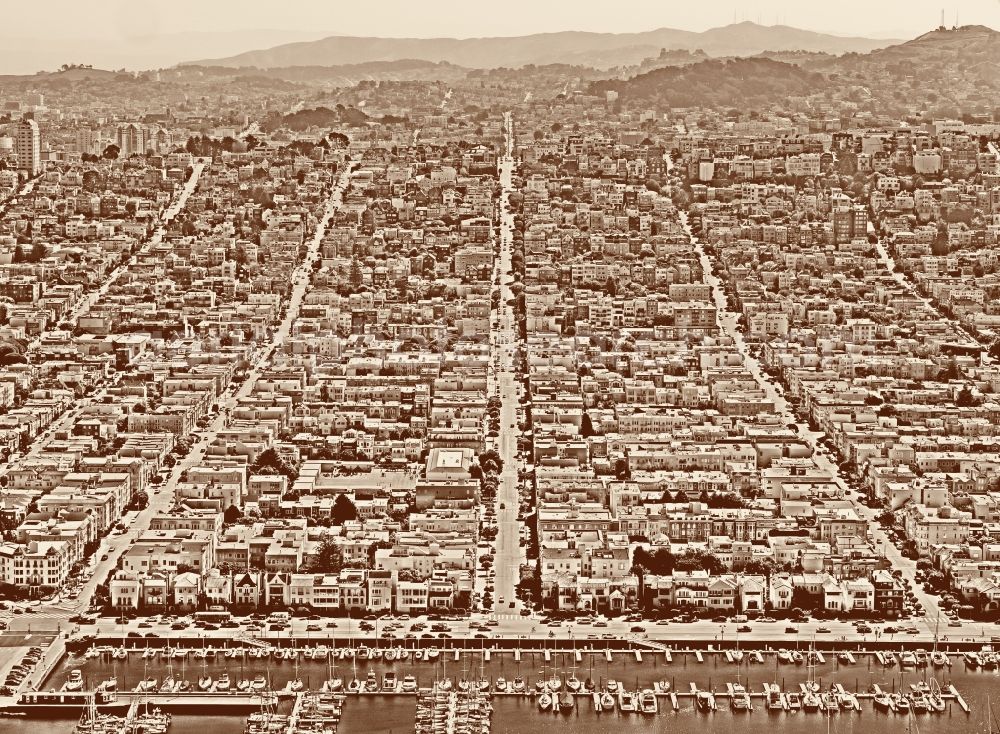 San Francisco from the bird's eye view: Pleasure boat marina with docks and moorings on the shore area St. Francis Yacht Club 99 Yacht Rd in San Francisco in USA. In the background, roads and residential areas of Divisadero Street, Scott street and Broderick street