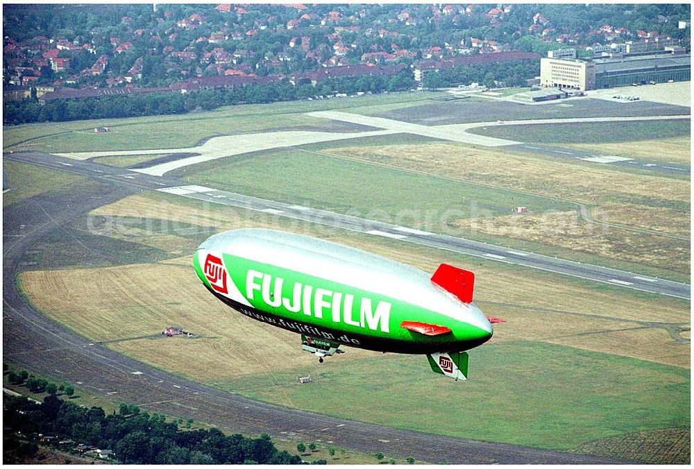 Aerial image Berlin - 11.08.2004 Zeppelin der Firma WDL Mülheim an der Ruhr über Berlin- Tempelhof mit Blick auf das Hauptgebäude des Flughafens Tempelhof und Wohnungen am Platz der Luftbrücke Kontaktadresse WDL Luftschiffgesellschaft mbH Flughafen 45470 Mülheim an der Ruhr, Germany Telefon: 02 08 - 37 80 80, Telefax: 02 08 - 37 80 841