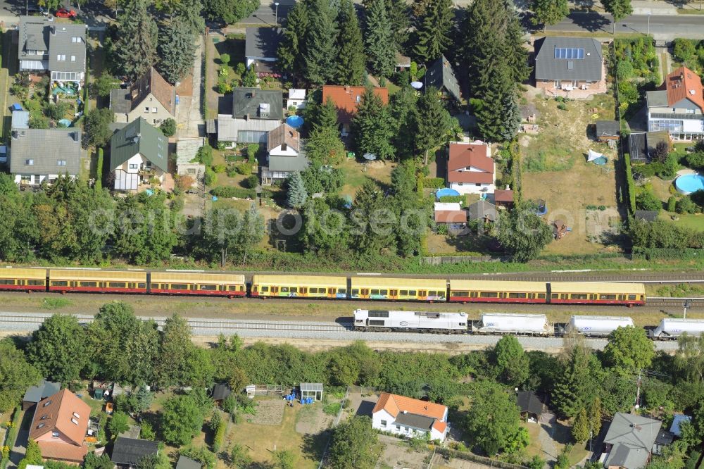 Aerial photograph Berlin - Trains passing through a single-family residential area of settlement at the Wilhelmsmuehlenweg in Berlin in Germany