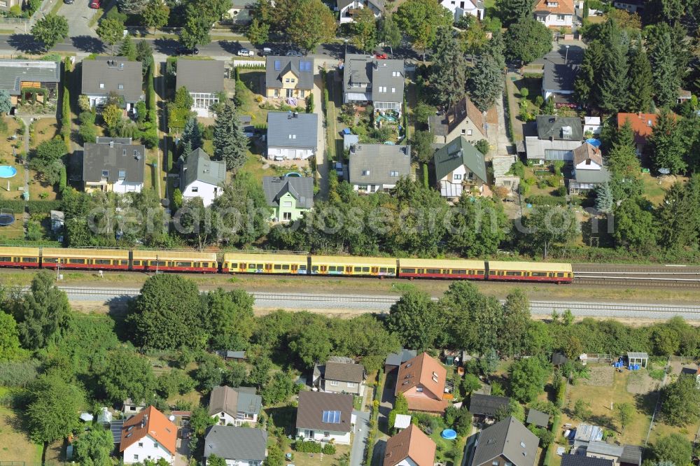 Berlin from the bird's eye view: Trains passing through a single-family residential area of settlement at the Wilhelmsmuehlenweg in Berlin in Germany