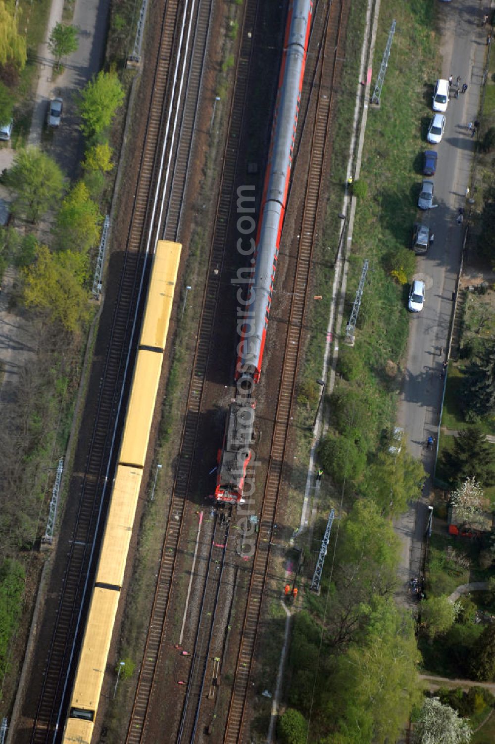 Berlin from above - Blick auf einen verunglückten Nahverkehrszug der Bahn nahe dem S-Bahnhof Karow. Der Regionalexpress aus Stralsund war am späten Abend des 16. April mit 22 Reisenden und Bahn-Personal im Bahnhof Berlin-Karow auf einen langsam fahrenden Güterzug aufgefahren. Die Verletzten wurden in umliegende Krankenhäuser gebracht. Der Triebwagen und der erste Waggon des Regionalexpress waren bei dem Zusammenstoß entgleist. Der Lokführer wurde durch den Aufprall in seinem Führerhaus eingeklemmt und musste von der Feuerwehr durch die Frontscheibe befreit werden.