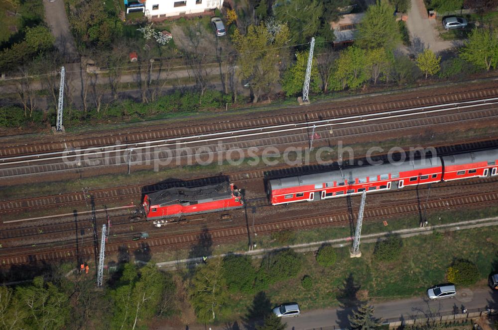 Aerial photograph Berlin - Blick auf einen verunglückten Nahverkehrszug der Bahn nahe dem S-Bahnhof Karow. Der Regionalexpress aus Stralsund war am späten Abend des 16. April mit 22 Reisenden und Bahn-Personal im Bahnhof Berlin-Karow auf einen langsam fahrenden Güterzug aufgefahren. Die Verletzten wurden in umliegende Krankenhäuser gebracht. Der Triebwagen und der erste Waggon des Regionalexpress waren bei dem Zusammenstoß entgleist. Der Lokführer wurde durch den Aufprall in seinem Führerhaus eingeklemmt und musste von der Feuerwehr durch die Frontscheibe befreit werden.