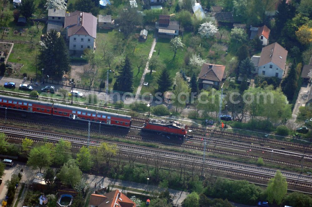 Berlin from the bird's eye view: Blick auf einen verunglückten Nahverkehrszug der Bahn nahe dem S-Bahnhof Karow. Der Regionalexpress aus Stralsund war am späten Abend des 16. April mit 22 Reisenden und Bahn-Personal im Bahnhof Berlin-Karow auf einen langsam fahrenden Güterzug aufgefahren. Die Verletzten wurden in umliegende Krankenhäuser gebracht. Der Triebwagen und der erste Waggon des Regionalexpress waren bei dem Zusammenstoß entgleist. Der Lokführer wurde durch den Aufprall in seinem Führerhaus eingeklemmt und musste von der Feuerwehr durch die Frontscheibe befreit werden.