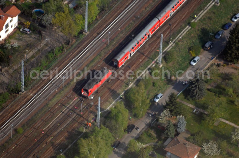 Aerial image Berlin - Blick auf einen verunglückten Nahverkehrszug der Bahn nahe dem S-Bahnhof Karow. Der Regionalexpress aus Stralsund war am späten Abend des 16. April mit 22 Reisenden und Bahn-Personal im Bahnhof Berlin-Karow auf einen langsam fahrenden Güterzug aufgefahren. Die Verletzten wurden in umliegende Krankenhäuser gebracht. Der Triebwagen und der erste Waggon des Regionalexpress waren bei dem Zusammenstoß entgleist. Der Lokführer wurde durch den Aufprall in seinem Führerhaus eingeklemmt und musste von der Feuerwehr durch die Frontscheibe befreit werden.