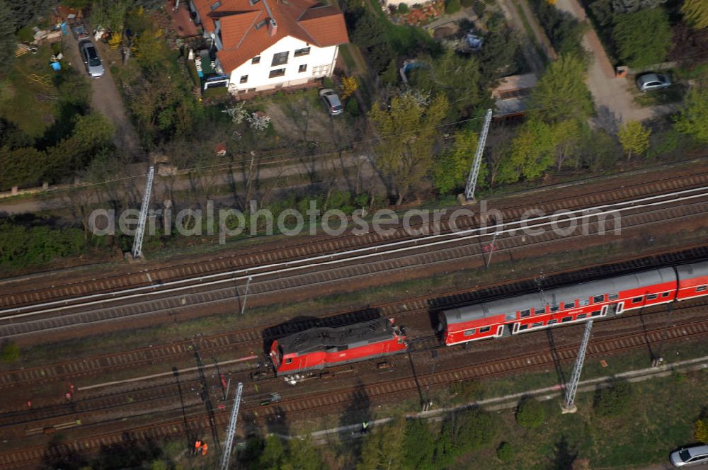 Aerial photograph Berlin - Blick auf einen verunglückten Nahverkehrszug der Bahn nahe dem S-Bahnhof Karow. Der Regionalexpress aus Stralsund war am späten Abend des 16. April mit 22 Reisenden und Bahn-Personal im Bahnhof Berlin-Karow auf einen langsam fahrenden Güterzug aufgefahren. Die Verletzten wurden in umliegende Krankenhäuser gebracht. Der Triebwagen und der erste Waggon des Regionalexpress waren bei dem Zusammenstoß entgleist. Der Lokführer wurde durch den Aufprall in seinem Führerhaus eingeklemmt und musste von der Feuerwehr durch die Frontscheibe befreit werden.