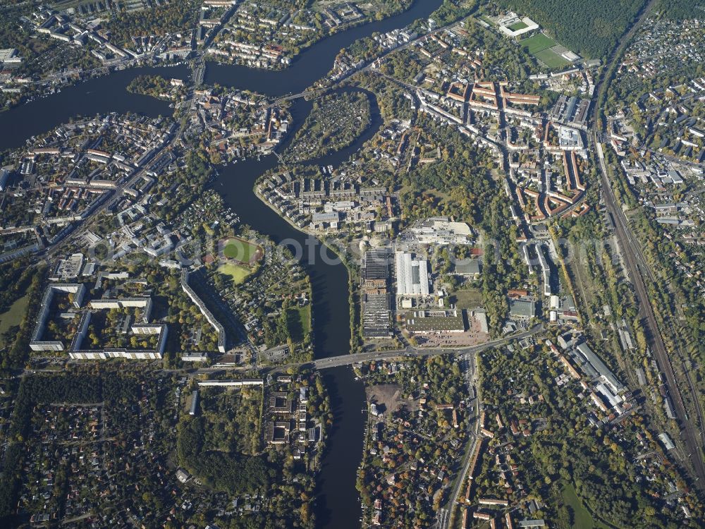 Berlin from above - The river junctions of Spree, Dahme and Mueggelspree in the district of Treptow-Koepenick in Berlin. The rivers Dahme and Spree meet in the Koepenick part of the district and circumvent the Baumgarteninsel island. Several bridges, such as the Lange Bridge or the Bridge of the Lindenstrasse street span the rivers. Wuhlheide forest area and the football stadium An der Alten Foersterei area located in the North of the rivers. Salvador-Allende bridge spans the Mueggelspree river in the East and connects the Koepenick and Friedrichshagen parts of the district