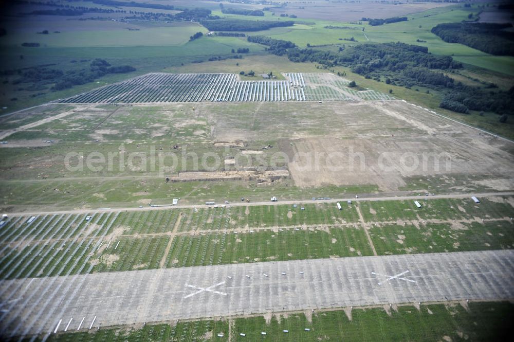 Tutow from the bird's eye view: Neuer zweiter Bauabschnitt des Solarenergiepark am Flugplatz Tutow in Mecklenburg - Vorpommern. Die juwi solar GmbH errichtet hier auf ca. 21 Hektar einen Solarpark mit ca. 65.500 Quadratmetern Solarmodulfläche bei ca. 91.000200 Einzelmodulen und einer Nennleistung von ca. 6780 Kilowattstunden jährlich. Modulhersteller ist die First Solar GmbH, die Unterkonstruktionen werden von der Fa. Schletter Leichtmetallbau GmbH errichtet. View of the second section of the solar energy park at the airport Tutow in Mecklenburg - Western Pomerania.