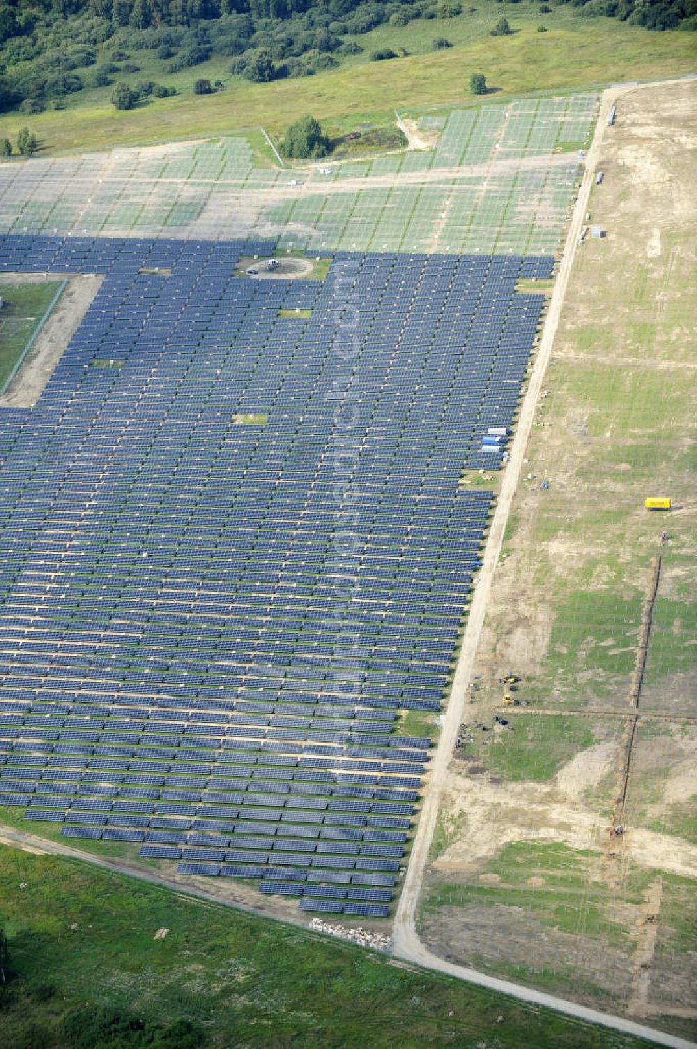 Tutow from the bird's eye view: Neuer zweiter Bauabschnitt des Solarenergiepark am Flugplatz Tutow in Mecklenburg - Vorpommern. Die juwi solar GmbH errichtet hier auf ca. 21 Hektar einen Solarpark mit ca. 65.500 Quadratmetern Solarmodulfläche bei ca. 91.000200 Einzelmodulen und einer Nennleistung von ca. 6780 Kilowattstunden jährlich. Modulhersteller ist die First Solar GmbH, die Unterkonstruktionen werden von der Fa. Schletter Leichtmetallbau GmbH errichtet. View of the second section of the solar energy park at the airport Tutow in Mecklenburg - Western Pomerania.