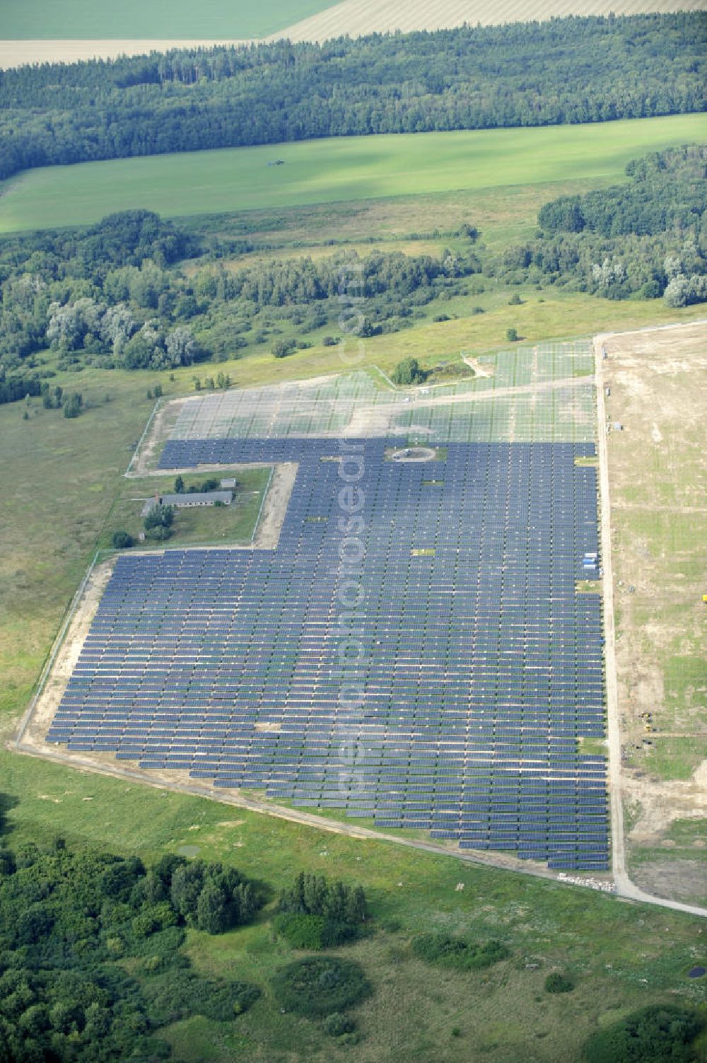 Aerial image Tutow - Neuer zweiter Bauabschnitt des Solarenergiepark am Flugplatz Tutow in Mecklenburg - Vorpommern. Die juwi solar GmbH errichtet hier auf ca. 21 Hektar einen Solarpark mit ca. 65.500 Quadratmetern Solarmodulfläche bei ca. 91.000200 Einzelmodulen und einer Nennleistung von ca. 6780 Kilowattstunden jährlich. Modulhersteller ist die First Solar GmbH, die Unterkonstruktionen werden von der Fa. Schletter Leichtmetallbau GmbH errichtet. View of the second section of the solar energy park at the airport Tutow in Mecklenburg - Western Pomerania.