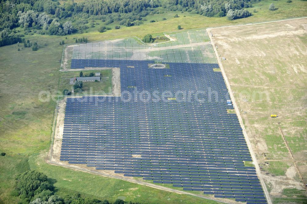 Aerial photograph Tutow - Neuer zweiter Bauabschnitt des Solarenergiepark am Flugplatz Tutow in Mecklenburg - Vorpommern. Die juwi solar GmbH errichtet hier auf ca. 21 Hektar einen Solarpark mit ca. 65.500 Quadratmetern Solarmodulfläche bei ca. 91.000200 Einzelmodulen und einer Nennleistung von ca. 6780 Kilowattstunden jährlich. Modulhersteller ist die First Solar GmbH, die Unterkonstruktionen werden von der Fa. Schletter Leichtmetallbau GmbH errichtet. View of the second section of the solar energy park at the airport Tutow in Mecklenburg - Western Pomerania.