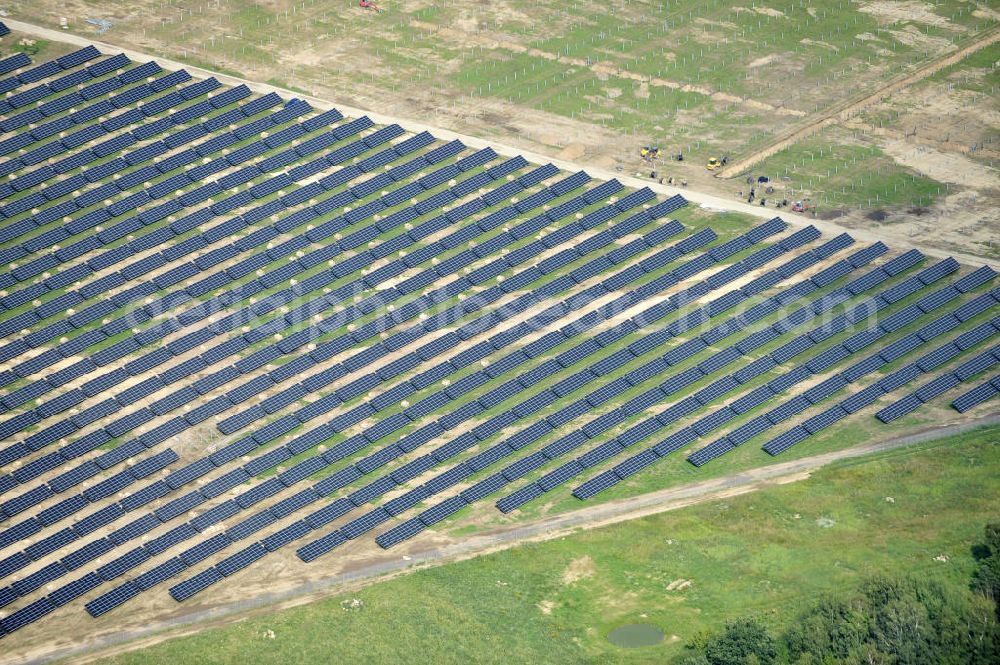 Tutow from the bird's eye view: Neuer zweiter Bauabschnitt des Solarenergiepark am Flugplatz Tutow in Mecklenburg - Vorpommern. Die juwi solar GmbH errichtet hier auf ca. 21 Hektar einen Solarpark mit ca. 65.500 Quadratmetern Solarmodulfläche bei ca. 91.000200 Einzelmodulen und einer Nennleistung von ca. 6780 Kilowattstunden jährlich. Modulhersteller ist die First Solar GmbH, die Unterkonstruktionen werden von der Fa. Schletter Leichtmetallbau GmbH errichtet. View of the second section of the solar energy park at the airport Tutow in Mecklenburg - Western Pomerania.