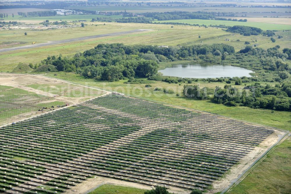 Tutow from the bird's eye view: Neuer zweiter Bauabschnitt des Solarenergiepark am Flugplatz Tutow in Mecklenburg - Vorpommern. Die juwi solar GmbH errichtet hier auf ca. 21 Hektar einen Solarpark mit ca. 65.500 Quadratmetern Solarmodulfläche bei ca. 91.000200 Einzelmodulen und einer Nennleistung von ca. 6780 Kilowattstunden jährlich. Modulhersteller ist die First Solar GmbH, die Unterkonstruktionen werden von der Fa. Schletter Leichtmetallbau GmbH errichtet. View of the second section of the solar energy park at the airport Tutow in Mecklenburg - Western Pomerania.