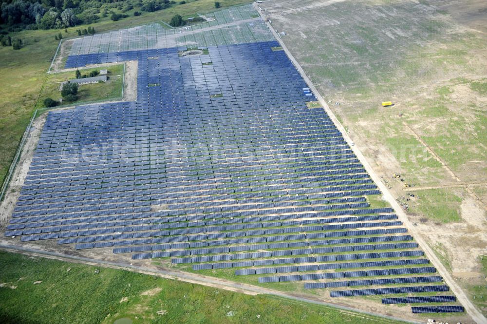 Tutow from the bird's eye view: Neuer zweiter Bauabschnitt des Solarenergiepark am Flugplatz Tutow in Mecklenburg - Vorpommern. Die juwi solar GmbH errichtet hier auf ca. 21 Hektar einen Solarpark mit ca. 65.500 Quadratmetern Solarmodulfläche bei ca. 91.000200 Einzelmodulen und einer Nennleistung von ca. 6780 Kilowattstunden jährlich. Modulhersteller ist die First Solar GmbH, die Unterkonstruktionen werden von der Fa. Schletter Leichtmetallbau GmbH errichtet. View of the second section of the solar energy park at the airport Tutow in Mecklenburg - Western Pomerania.