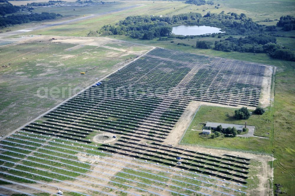 Tutow from the bird's eye view: Neuer zweiter Bauabschnitt des Solarenergiepark am Flugplatz Tutow in Mecklenburg - Vorpommern. Die juwi solar GmbH errichtet hier auf ca. 21 Hektar einen Solarpark mit ca. 65.500 Quadratmetern Solarmodulfläche bei ca. 91.000200 Einzelmodulen und einer Nennleistung von ca. 6780 Kilowattstunden jährlich. Modulhersteller ist die First Solar GmbH, die Unterkonstruktionen werden von der Fa. Schletter Leichtmetallbau GmbH errichtet. View of the second section of the solar energy park at the airport Tutow in Mecklenburg - Western Pomerania.