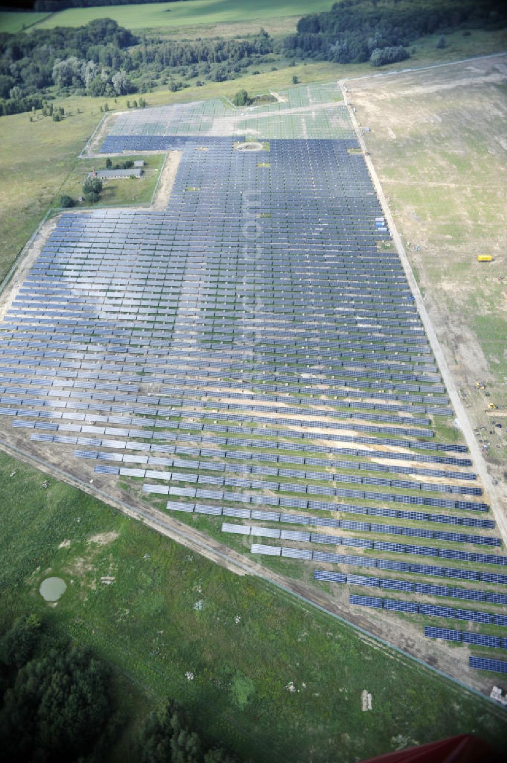 Aerial image Tutow - Neuer zweiter Bauabschnitt des Solarenergiepark am Flugplatz Tutow in Mecklenburg - Vorpommern. Die juwi solar GmbH errichtet hier auf ca. 21 Hektar einen Solarpark mit ca. 65.500 Quadratmetern Solarmodulfläche bei ca. 91.000200 Einzelmodulen und einer Nennleistung von ca. 6780 Kilowattstunden jährlich. Modulhersteller ist die First Solar GmbH, die Unterkonstruktionen werden von der Fa. Schletter Leichtmetallbau GmbH errichtet. View of the second section of the solar energy park at the airport Tutow in Mecklenburg - Western Pomerania.