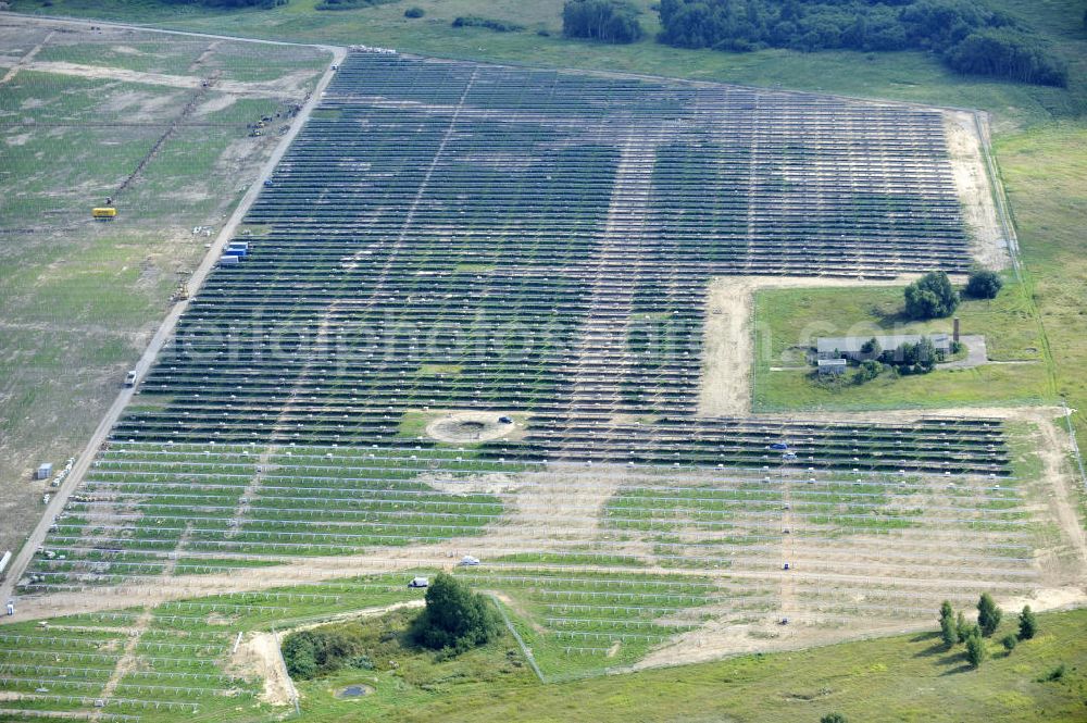 Aerial image Tutow - Neuer zweiter Bauabschnitt des Solarenergiepark am Flugplatz Tutow in Mecklenburg - Vorpommern. Die juwi solar GmbH errichtet hier auf ca. 21 Hektar einen Solarpark mit ca. 65.500 Quadratmetern Solarmodulfläche bei ca. 91.000200 Einzelmodulen und einer Nennleistung von ca. 6780 Kilowattstunden jährlich. Modulhersteller ist die First Solar GmbH, die Unterkonstruktionen werden von der Fa. Schletter Leichtmetallbau GmbH errichtet. View of the second section of the solar energy park at the airport Tutow in Mecklenburg - Western Pomerania.