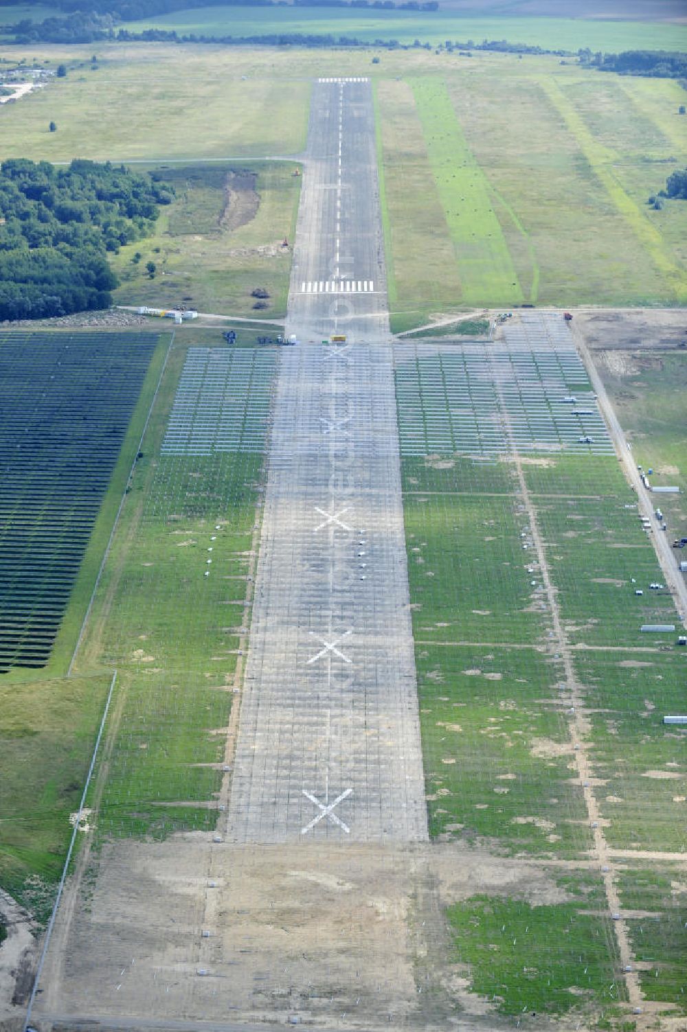 Tutow from the bird's eye view: Neuer zweiter Bauabschnitt des Solarenergiepark am Flugplatz Tutow in Mecklenburg - Vorpommern. Die juwi solar GmbH errichtet hier auf ca. 21 Hektar einen Solarpark mit ca. 65.500 Quadratmetern Solarmodulfläche bei ca. 91.000200 Einzelmodulen und einer Nennleistung von ca. 6780 Kilowattstunden jährlich. Modulhersteller ist die First Solar GmbH, die Unterkonstruktionen werden von der Fa. Schletter Leichtmetallbau GmbH errichtet. View of the second section of the solar energy park at the airport Tutow in Mecklenburg - Western Pomerania.