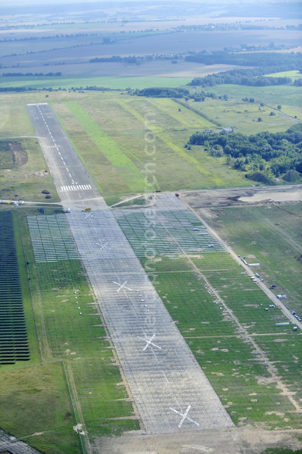 Aerial image Tutow - Neuer zweiter Bauabschnitt des Solarenergiepark am Flugplatz Tutow in Mecklenburg - Vorpommern. Die juwi solar GmbH errichtet hier auf ca. 21 Hektar einen Solarpark mit ca. 65.500 Quadratmetern Solarmodulfläche bei ca. 91.000200 Einzelmodulen und einer Nennleistung von ca. 6780 Kilowattstunden jährlich. Modulhersteller ist die First Solar GmbH, die Unterkonstruktionen werden von der Fa. Schletter Leichtmetallbau GmbH errichtet. View of the second section of the solar energy park at the airport Tutow in Mecklenburg - Western Pomerania.