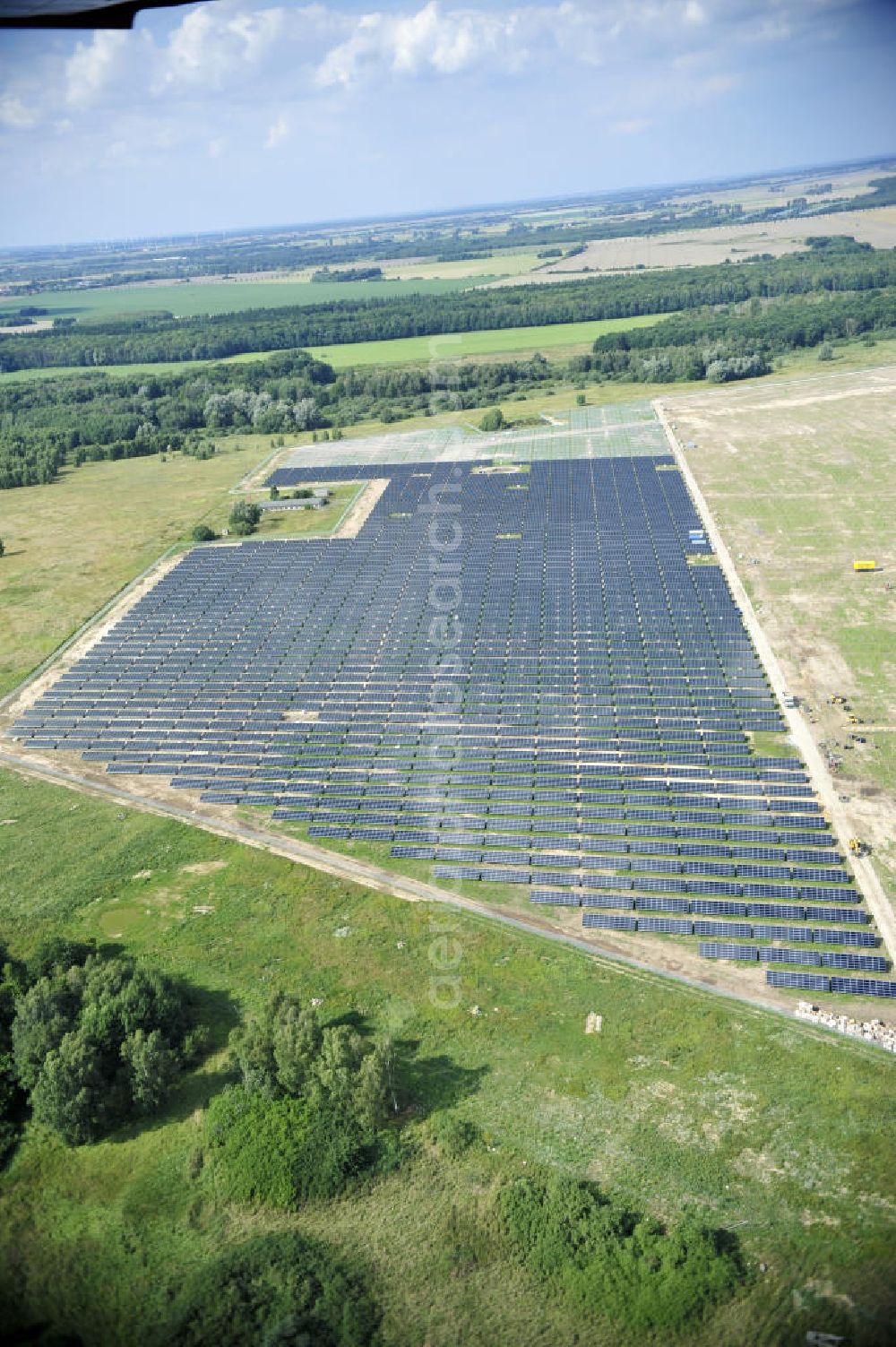 Aerial image Tutow - Neuer zweiter Bauabschnitt des Solarenergiepark am Flugplatz Tutow in Mecklenburg - Vorpommern. Die juwi solar GmbH errichtet hier auf ca. 21 Hektar einen Solarpark mit ca. 65.500 Quadratmetern Solarmodulfläche bei ca. 91.000200 Einzelmodulen und einer Nennleistung von ca. 6780 Kilowattstunden jährlich. Modulhersteller ist die First Solar GmbH, die Unterkonstruktionen werden von der Fa. Schletter Leichtmetallbau GmbH errichtet. View of the second section of the solar energy park at the airport Tutow in Mecklenburg - Western Pomerania.