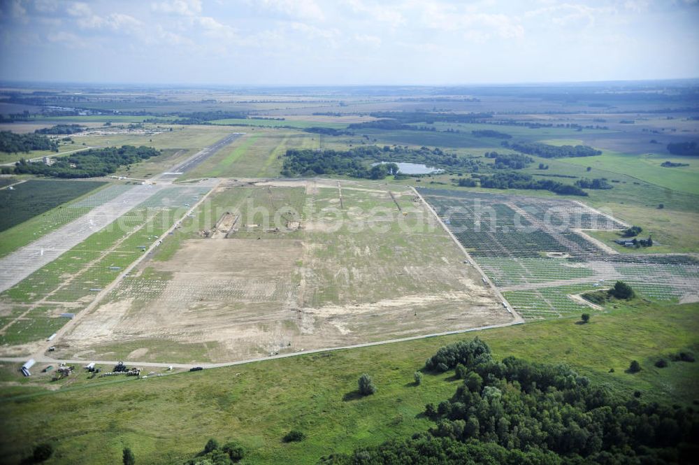 Tutow from the bird's eye view: Neuer zweiter Bauabschnitt des Solarenergiepark am Flugplatz Tutow in Mecklenburg - Vorpommern. Die juwi solar GmbH errichtet hier auf ca. 21 Hektar einen Solarpark mit ca. 65.500 Quadratmetern Solarmodulfläche bei ca. 91.000200 Einzelmodulen und einer Nennleistung von ca. 6780 Kilowattstunden jährlich. Modulhersteller ist die First Solar GmbH, die Unterkonstruktionen werden von der Fa. Schletter Leichtmetallbau GmbH errichtet. View of the second section of the solar energy park at the airport Tutow in Mecklenburg - Western Pomerania.