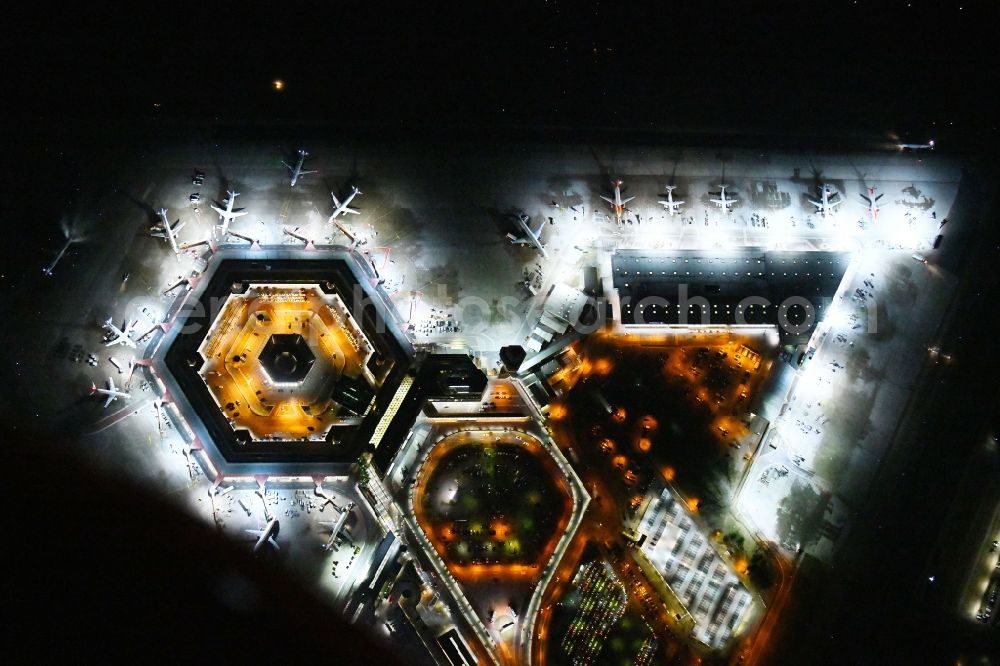 Vertical aerial photograph Berlin - Vertical aerial view from the satellite perspective with Night lighting Flight operations at the terminal of the airport Berlin - Tegel